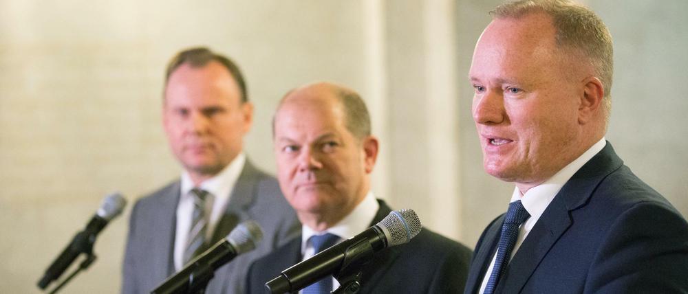 Hamburgs zurückgetretener Innensenator Michael Neumann (SPD, r) spricht am 18.01.2016 im Rathaus in Hamburg an der Seite von Hamburgs Erstem Bürgermeister Olaf Scholz (SPD) und dem Chef des Bezirksamts Mitte, Andy Grote (SPD, l). Grote wird Nachfolger von Hamburgs zurückgetretenem Innensenator Neumann.