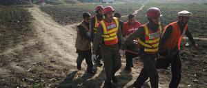 Pakistanische Rettungskräfte helfen einem Opfer der Angriffe auf eine Universität bei Peshawar.