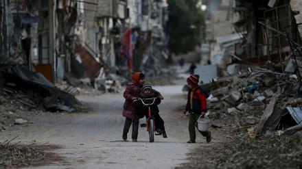 Drei syrische Kinder spielen in den vom Bürgerkrieg zerstörten Straßen von Joubar, einem Stadtteil von Damaskus.
