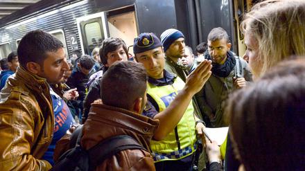Ein Polizist mit Flüchtlingen am Bahnhof in Stockholm (Archivbild).