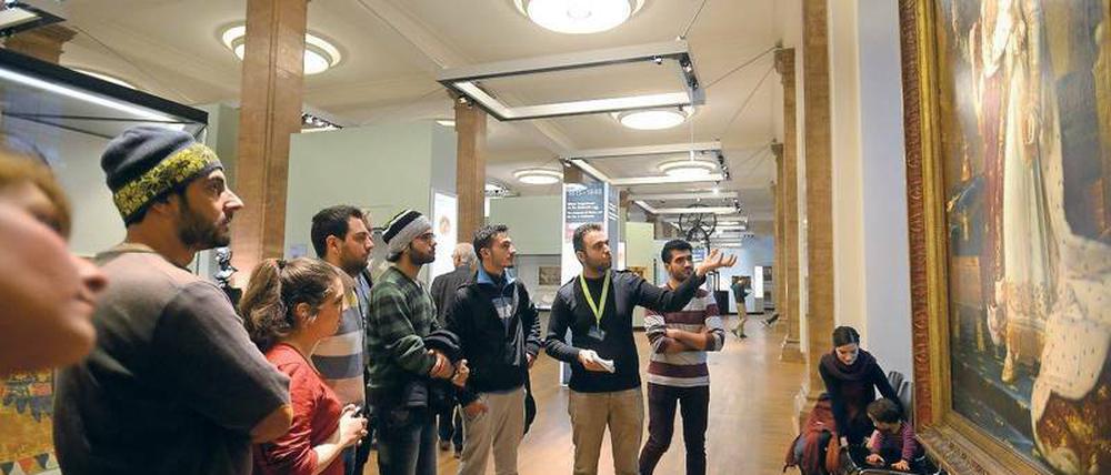 Gute Sicht. Bashar Almahfoud (mit grünem Bändchen) bei seiner Führung auf Arabisch im Deutschen Historischen Museum vor einem Bild Napoleons im Rahmen des Projekts "Multaka - Treffpunkt Museum".