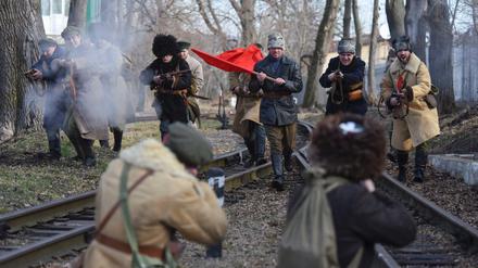 Nachgestellt. Diese Männer erinnern an den heroischen Kampf ukrainischer Studenten gegen die Rote Armee 1918 in Lemberg. In der Zentralukraine wurde derweil die Statue eines Kommunisten gestürzt. Symbole überlagern weiter die Politik.