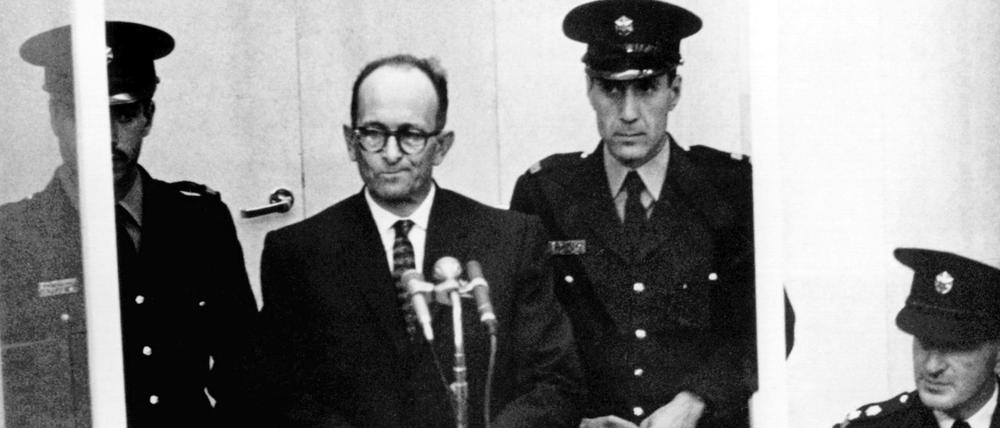 Der später zum Tode verurteilte NS-Kriegsverbrecher Adolf Eichmann (2.v.l) steht während seiner Vernehmung am ersten Prozesstag vor dem Bezirksgericht in Jerusalem (Archivfoto vom 11.04.1961).