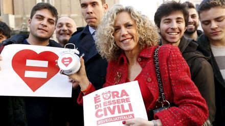 "Es wird Zeit, anständig zu sein", ein Spiel mit dem italienischen Wort für eingetragene Partnerschaft, die "unione civile", steht auf dem Flugblatt, das Senatorin Monica Cirinnà in der Hand hält. Cirinnà, hier mit Schwulen-Aktivisten vor dem Senat, ist Berichterstatterin für den Gesetzentwurf. 