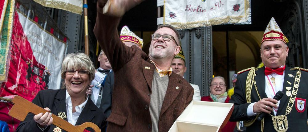 Bezirksbürgermeister Reinhard Naumann wirft am 11.11.2015 in Berlin vor dem Rathaus Charlottenburg Kamellen.