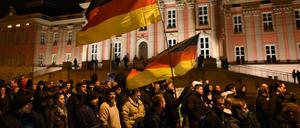 Bei der 3. Podiga-Demonstration  in Potsdam laufen Demonstranten am Landtag entlang.