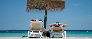 Ab nach Malle. Deutsche Urlauber am Strand an der Plaja de Muro im Norden der Mittelmeerinsel Mallorca.