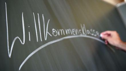 Der Lehrer Florian Schempp schreibt am 31.08.2015 an der Friedenauer Gemeinschaftsschule/1. Gemeinschaftsschule Schöneberg in Berlin das Wort "Willkommensklasse" an die Tafel. Foto: Britta Pedersen/dpa +++(c) dpa - Bildfunk+++