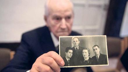 Leon Schwarzbaum zeigt ein Foto, auf dem er sich mit seinen Eltern und dem Onkel ablichten ließ. Alle drei wurden in Auschwitz ermordet.