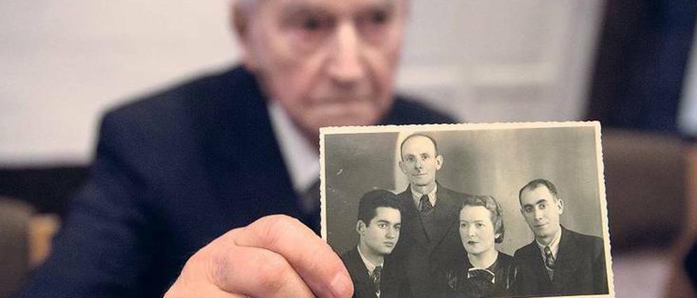 Leon Schwarzbaum zeigt ein Foto, auf dem er sich mit seinen Eltern und dem Onkel ablichten ließ. Alle drei wurden in Auschwitz ermordet.