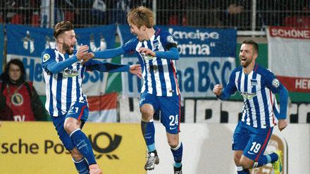 Berlins Genki Haraguchi (M) jubelt nach seinem Tor zum 3:1 mit Marvin Plattenhardt (l) und Vedad Ibisevic. 