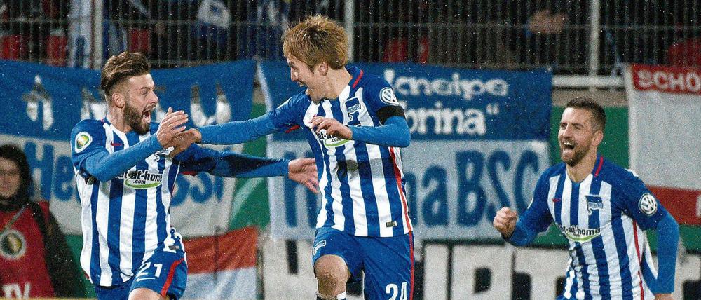 Berlins Genki Haraguchi (M) jubelt nach seinem Tor zum 3:1 mit Marvin Plattenhardt (l) und Vedad Ibisevic.