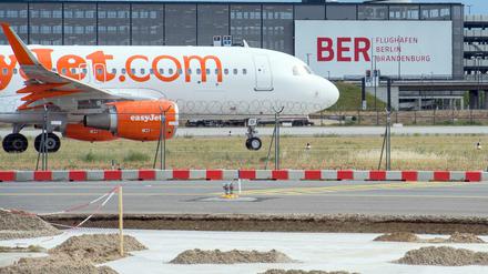 Die Baustelle der neuen Start- Und Landebahn des Flughafens Schönefeld (Brandenburg) und eine Passagiermaschine der der Fluggesellschaft Easyjet sind am 08.06.2015 vor dem zukünftigen Hauptstadtflughafen Berlin-Brandenburg Airport Willy Brandt (BER) zu sehen. Foto: Patrick Pleul/dpa (zu dpa «Oberverwaltungsgericht verhandelt über Klage gegen die Betriebsgenehmigung des Flughafens Berlin-Brandenburg» vom 19.01.2016) +++(c) dpa - Bildfunk+++