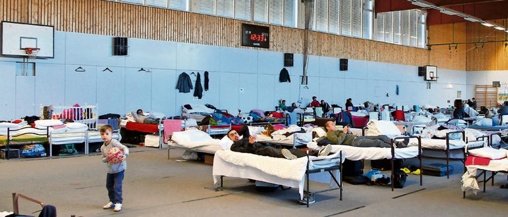 Flüchtlinge in einer Sporthalle.
