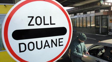 Ein Zollbeamter kontrolliert am Mittwoch (26.02.2003) in Rielasingen (Landkreis) Konstanz am dortigen Zollamt einen Autofahrer. Das größte Hauptzollamt an der deutsch-schweizerischen Grenze in Singen hat 2002 bei Reisenden Bargeld und Unterlagen über Schwarzgeldbeträge in Höhe von einer Milliarde Euro registriert. In diesem Jahr rechnet man nach der von der Bundesregierung angekündigten Steueramnestie mit einem Rückgang des Geldschmuggels. Fotograf: Patrick Seeger dpa/lsw ( zu THEMA DES TAGES)