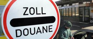 Ein Zollbeamter kontrolliert am Mittwoch (26.02.2003) in Rielasingen (Landkreis) Konstanz am dortigen Zollamt einen Autofahrer. Das größte Hauptzollamt an der deutsch-schweizerischen Grenze in Singen hat 2002 bei Reisenden Bargeld und Unterlagen über Schwarzgeldbeträge in Höhe von einer Milliarde Euro registriert. In diesem Jahr rechnet man nach der von der Bundesregierung angekündigten Steueramnestie mit einem Rückgang des Geldschmuggels. Fotograf: Patrick Seeger dpa/lsw ( zu THEMA DES TAGES)