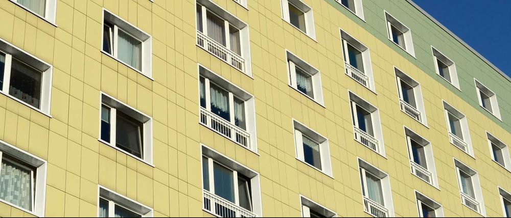 Ein Plattenbau in Berlin mit grün-gelber Fassade.