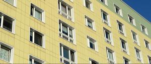 Ein Plattenbau in Berlin mit grün-gelber Fassade.