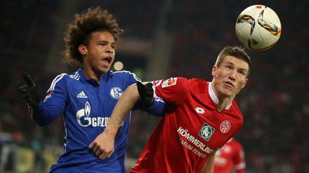 Der Mainzer Gaetan Bussmann (r) Köpft den ball vor dem Gelsenkirchener Leroy Sane (l) weg. 