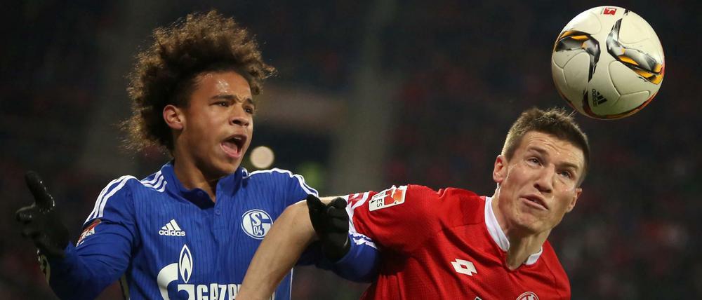 Der Mainzer Gaetan Bussmann (r) Köpft den ball vor dem Gelsenkirchener Leroy Sane (l) weg. 