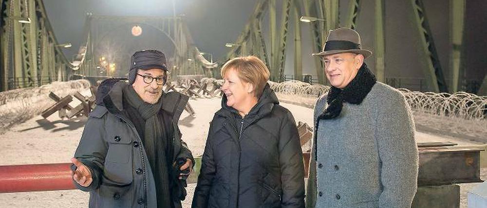 Auch Kanzlerin Angela Merkel hat ein Faible für Drehorte, wie sie beim Besuch auf der Glienicker Brücke am Set von Steven Spielbergs „Bridge of Spies“ zeigte. Tom Hanks (rechts) hat’s gefreut. 