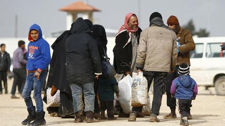 Syrische Flüchtlinge warten unweit von Azaz. Weil die syrischen Kurden dieses Gebiet unter ihre Kontrolle gebracht haben, bombardiert die Türkei nun ihre Stellungen.