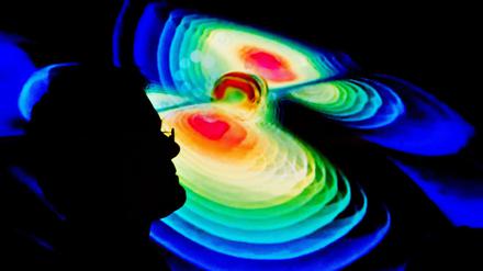 Der Schattenriss eines Mannes ist vor der Visualisierung der Gravitationswellen zu sehen.
