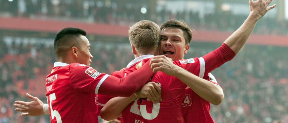 Unions Bobby Wood (links) und Fabian Schönheim (rechts) umarmen den Torschützen Felix Kroos nach seinem Treffer zum 1:0. Wood sollte sich später auch noch in die Torschützenliste eintragen. 