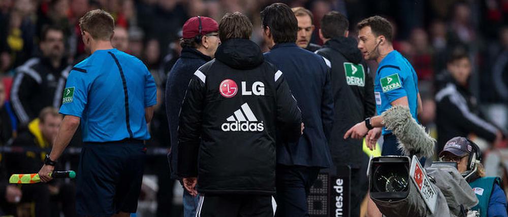 Felix Zwayer (r.) schickt Roger Schmidt auf die Tribüne. Der will nicht und deswegen unterbricht der Schiri das Spiel einfach mal.