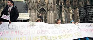Flüchtlinge am Kölner Dom entschuldigen sich für die Übergriffe auf Frauen in der Silvesternacht durch andere Migranten aus dem Maghreb. 