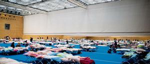 Voll, eng, provisorisch. Auch in einer Halle am Olympiapark sind Flüchtlinge untergebracht. Und so schnell wird sie wohl nicht geräumt werden.