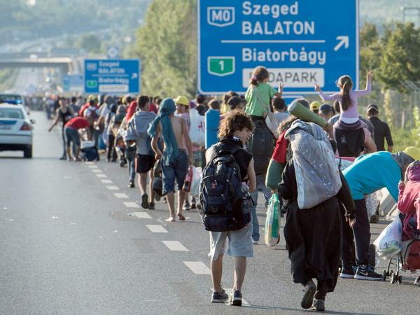 Anderes Land, ähnliche Bilder. Flüchtlinge aus Syrien, dem Irak und Afrika auf einer Autobahn in Ungarn beim "Marsch der Hoffnung" in Richtung Österreich.