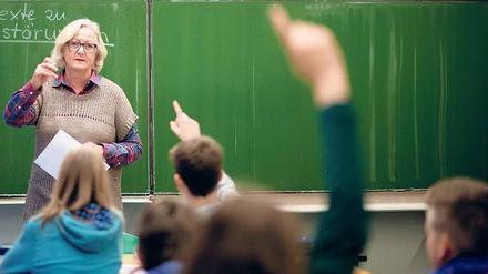 Vor der Klasse. Lehrkräfte unterrichten häufig allein. Dabei könnten sie viel erfahren, wenn Kollegen im Unterricht hospitieren und sie sich mit ihnen austauschen. 