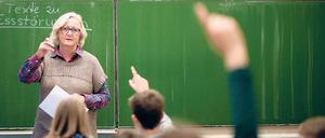 Vor der Klasse. Lehrkräfte unterrichten häufig allein. Dabei könnten sie viel erfahren, wenn Kollegen im Unterricht hospitieren und sie sich mit ihnen austauschen. 