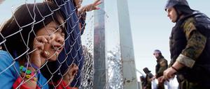 Gestoppt.  Ein Flüchtlingsmädchen weint und umklammert einen Zaun im mazedonischen Gevgelija. Am dortigen Grenzübergang kommen nur noch syrische und irakische Flüchtlinge durch.