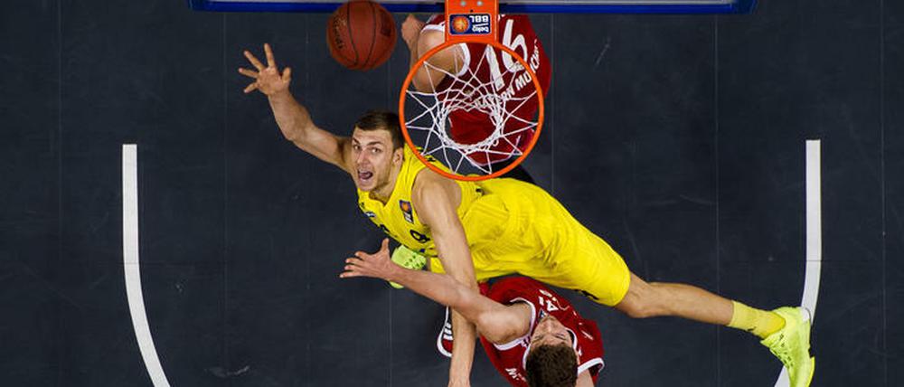 Immer nach oben schauen. Alba Berlin, hier Elmedin Kikanovic in Gelb gegen den Münchner Daniel Mayr, will ins Pokalfinale am Sonntag einziehen.
