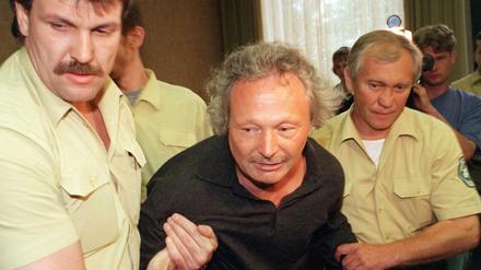 Gestützt von Justizgeamten wird Harald Zirngibl (M), bekannt als "Besenstielräuber" am 16.09.1999 zur Verhandlung vor dem Landgericht München geführt. Der Mann hat den FC Bayern München um einen Millionenbetrag erpressen wollen und ist am Montag auf einem Parkplatz im niederbayerischen Mainburg festgenommen worden.