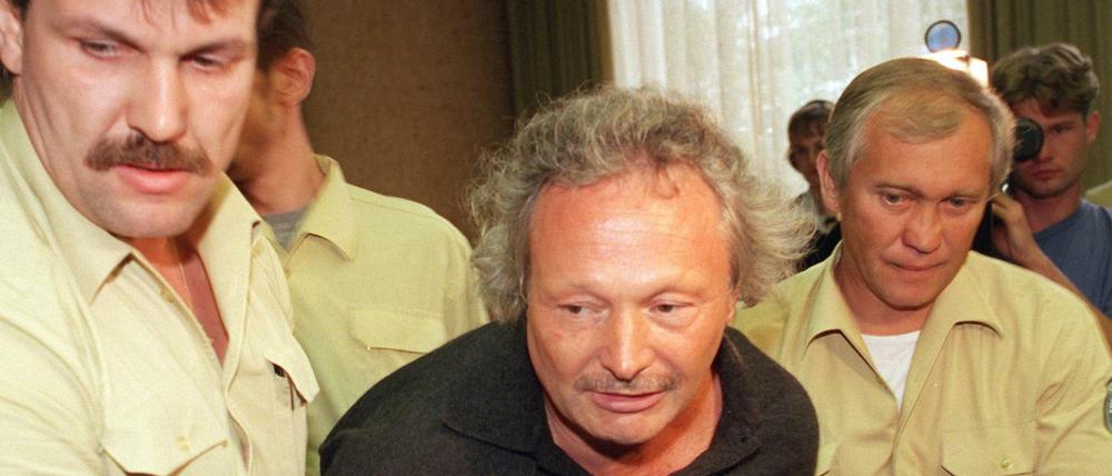 Gestützt von Justizgeamten wird Harald Zirngibl (M), bekannt als "Besenstielräuber" am 16.09.1999 zur Verhandlung vor dem Landgericht München geführt. Der Mann hat den FC Bayern München um einen Millionenbetrag erpressen wollen und ist am Montag auf einem Parkplatz im niederbayerischen Mainburg festgenommen worden.