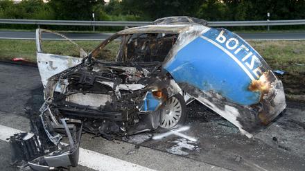 Ein ausgebrannter Streifenwagen der Polizei steht am 02.07.2015 auf der Autobahn 44 bei Lichtenau (Kreis Paderborn). Am Dienstag beginnt in Paderborn ein Prozess gegen einen Lkw-Fahrer wegen fahrlässiger Tötung zweier Polizisten.