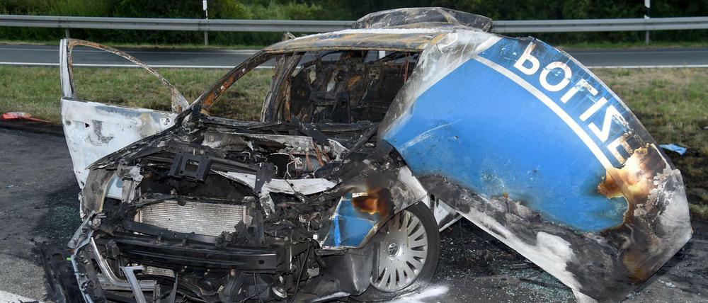 Ein ausgebrannter Streifenwagen der Polizei steht am 02.07.2015 auf der Autobahn 44 bei Lichtenau (Kreis Paderborn). Am Dienstag beginnt in Paderborn ein Prozess gegen einen Lkw-Fahrer wegen fahrlässiger Tötung zweier Polizisten.