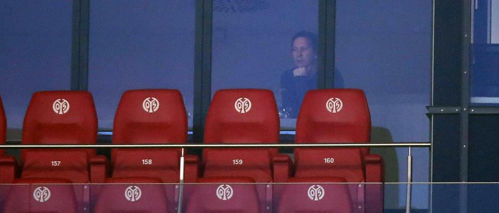 Der Leverkusener Trainer Roger Schmidt schaut sich das Spiel aus einer Loge durch die Scheibe an. 