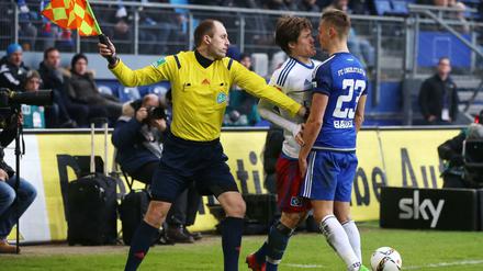 Hamburgs Gotoku Sakai und Ingolstadts Robert Bauer (r) rangeln auf dem Platz.