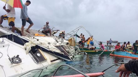 Philippinische Fischer auf dem gekenterten Boot, auf dem am Wochenende die Leiche eines Deutschen gefunden wurde.