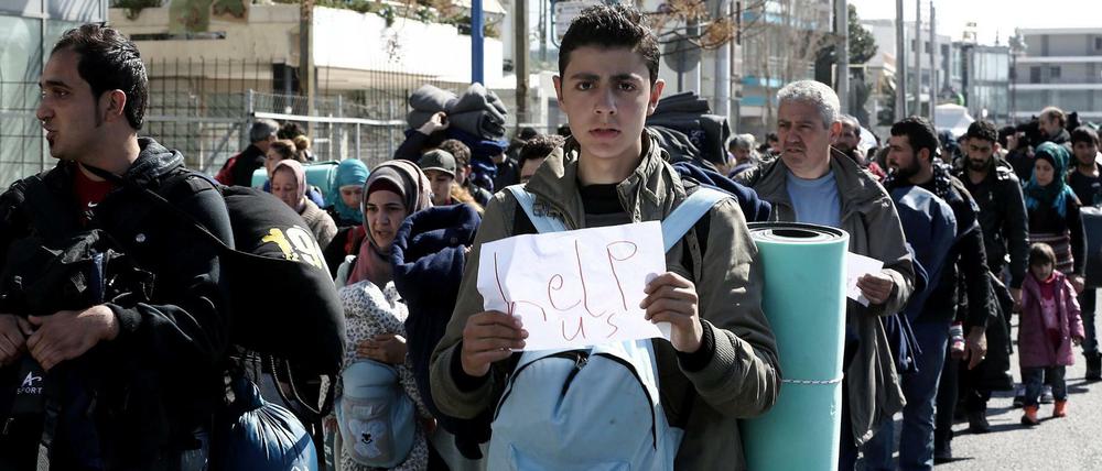 Flüchtlinge in Griechenland. Migranten machen sich in Athen von einem ehemaligen Flughafen, der als Aufnahmelager dient, auf den Weg zum Bahnhof.