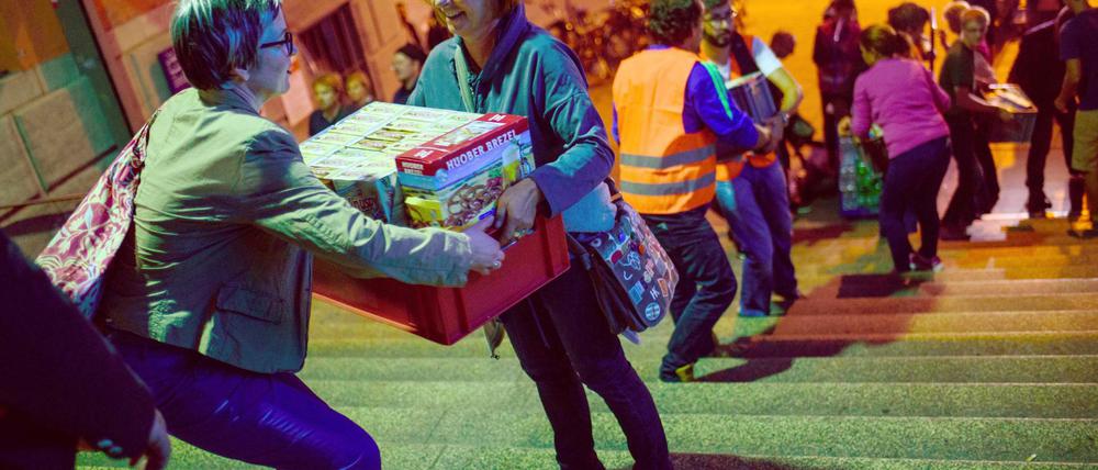 Helferinnen beim Kistenschleppen - erst einmal für die Erstunterkunft (hier in München). Später muss der Staat sich mit Wohnsitzvorschriften zurückhalten.
