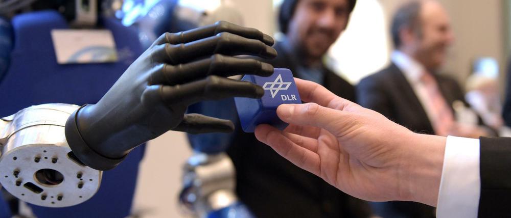 Hand in Hand. Künftig sollen Roboter und Menschen in der Industrie ganz eng zusammenarbeiten.