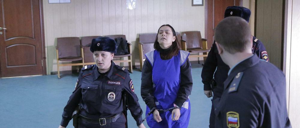 Gyulchehra Bobokulova wird von Polizisten in Russland in Untersuchungshaft gebracht. Die Frau war mit einem abgetrennten Kinderkopf an einer U-Bahn-Station im Moskau verhaftet worden.