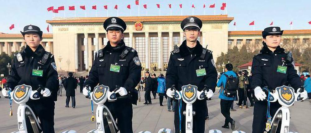 Mobile Wachposten. Chinesische Polizisten posieren vor der Großen Halle des Volkes in Peking. Foto: Wu Hong/dpa