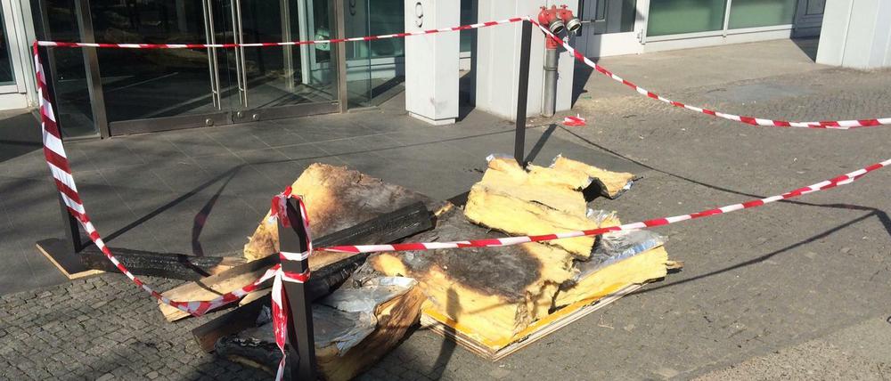Dämmmaterial und Dachbalken aus der abgebrannten Flüchtlingsunterkunft in Nauen liegen vor der AfD-Geschäftsstelle in Berlin-Tiergarten