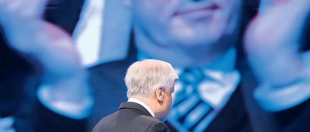 Aus dem im Hintergrund. Horst Seehofer verlässt beim CSU-Parteitag im November die Bühne, von der Leinwand klatscht Markus Söder ihm Beifall.